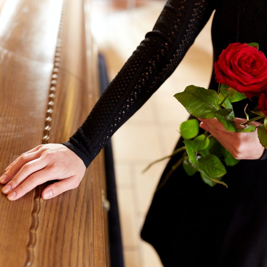 woman-with-red-roses-and-coffin-at-funeral-1.jpg